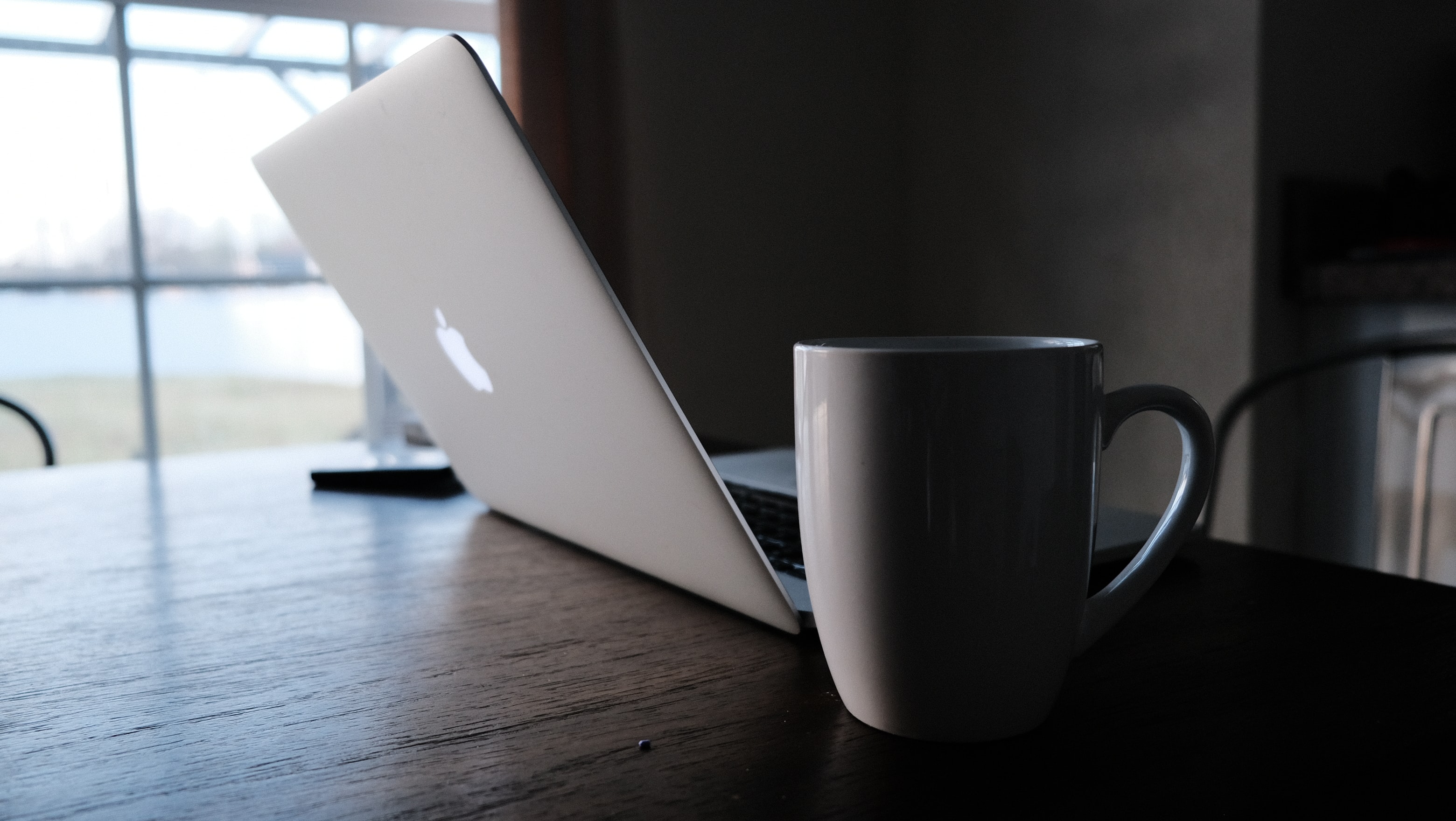 Coffee mug next to a laptop
